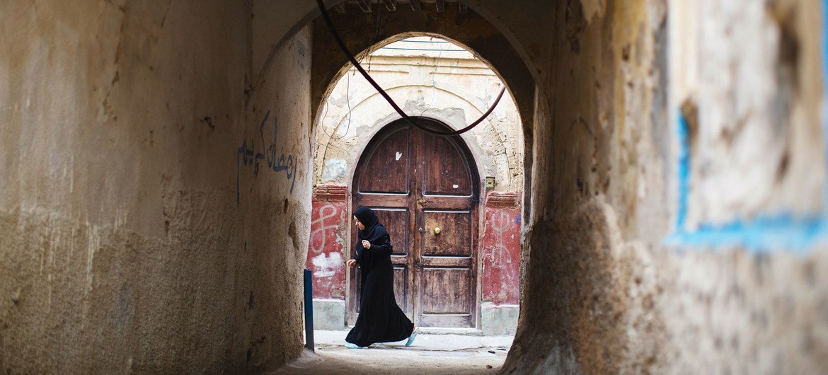 Uma mulher caminha na cidade velha de Trípoli, na Líbia