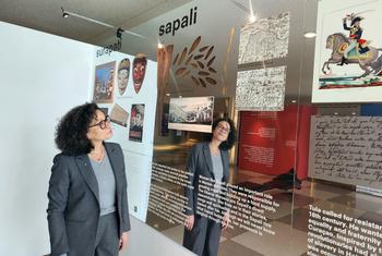 A woman with glasses looks at an exhibition about slavery history at the Rijksmuseum, which features wooden foot stocks known as a 'tronco'.
