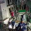 Un equipo de rescate chino intenta rescatar a una persona atrapada en el interior de un edificio de apartamentos derrumbado en Mandalay, Myanmar. 
