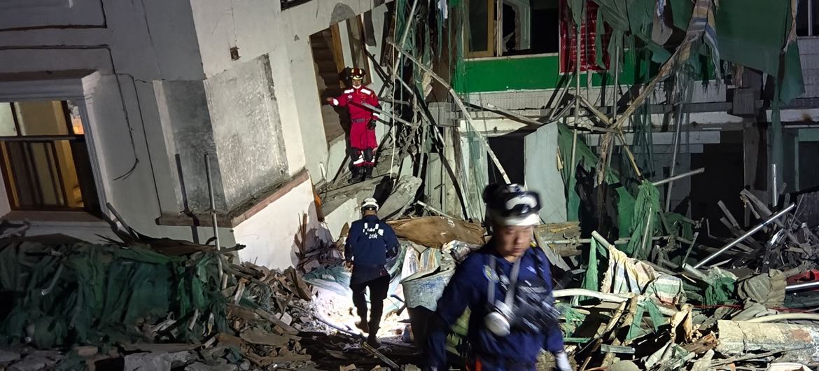 Los equipos de rescate se abren paso entre los escombros de un edificio derrumbado durante la noche en Myanmar tras un terremoto.