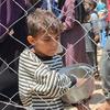 A Palestinian child in Gaza after receiving a meal during food distribution in central Gaza.