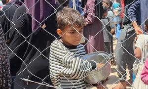 Un niño palestino en Gaza tras recibir una comida durante la distribución de alimentos en el centro de Gaza.