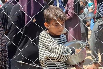 Uma criança palestina em Gaza após receber uma refeição durante a distribuição de alimentos