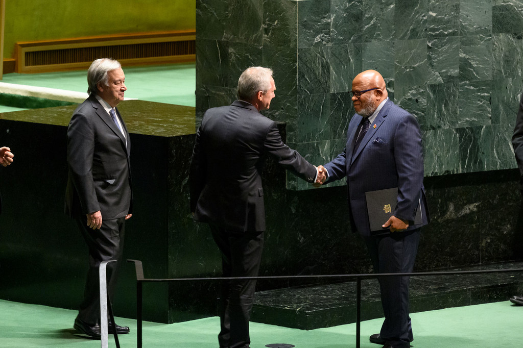 L'actuel Président de l'Assemblée générale, Csaba Kőrösi (au centre), salue l'ambassadeur Dennis Francis de Trinité-et-Tobago, Président élu de la 78e session de l'Assemblée générale des Nations Unies. Le Secrétaire général António Guterres regarde la sc…