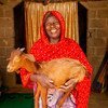 在尼日利亚迈杜古里的贡古龙，一名妇女怀抱着从粮农组织获得的一只山羊。