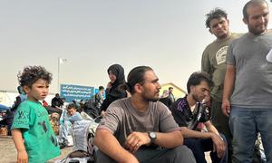 Des Afghans récemment arrivés d'Iran se rassemblent au poste frontière d'Islam Qala.