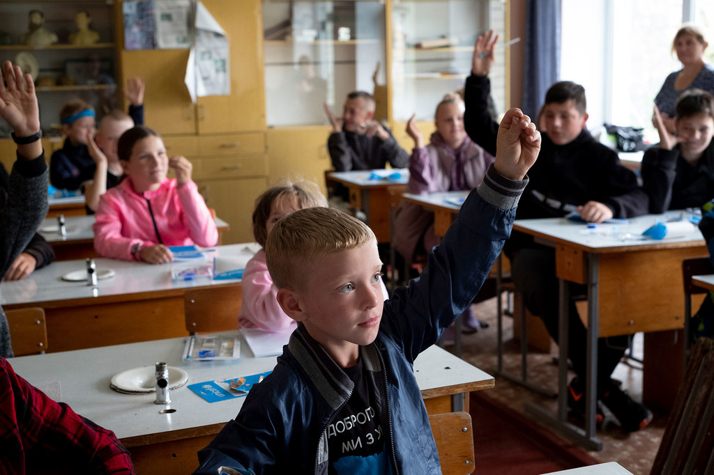 Les enfants vont en classe dans une école d’Olyzarivka, en Ukraine. Le village a été une ligne de front pendant des semaines pendant le conflit et a été gravement endommagé.