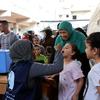 Ferial, une grand-mère, a emmené ses deux petites filles au centre de santé de Deir El Balah pour les faire vacciner contre la polio.