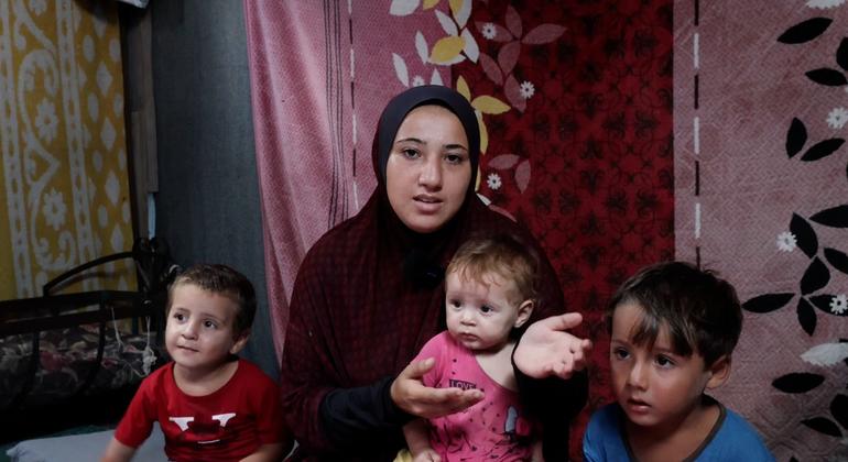 Norhan Shamlakh com seus três filhos em Deir El Balah, Gaza, se preparando para ir a um centro de saúde onde seus filhos receberão a vacinação contra a poliomielite.