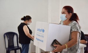 A woman collects a hygiene kit in Bourj Hummoud, Lebanon. (file)