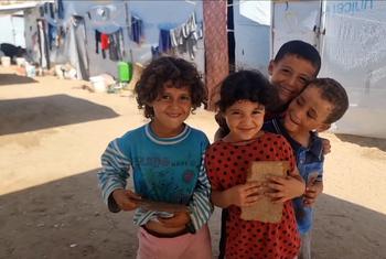 Crianças órfãs reunidas num espaço aberto no campo Al-Baraka, na área de Al-Mawasi, em Khan Younis