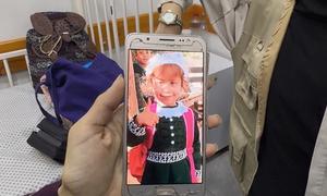 La madre de Jana muestra en su teléfono una foto de Jana antes de padecer hambruna. 