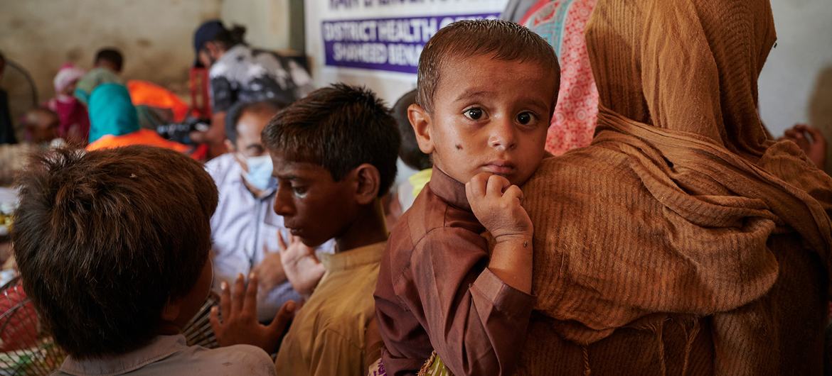 在巴基斯坦信德省一个拥挤的流动医疗诊所，受严重洪灾影响的人们前来候诊。