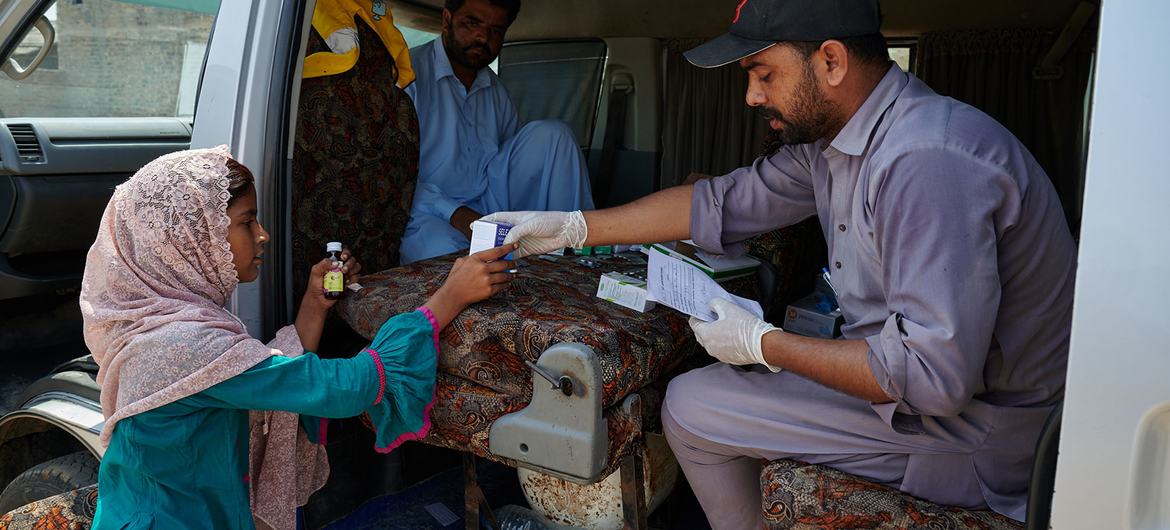 فتاة صغيرة تحصل على أدويتها من وحدة صحية متنقلة أُنشئت لضحايا الفيضانات في منطقة شانغار ، باكستان.