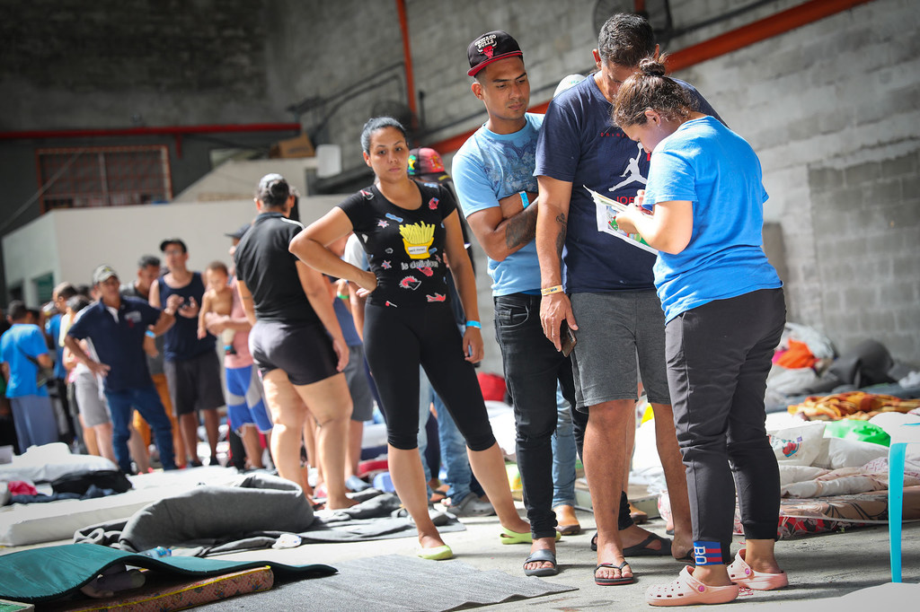 Los migrantes venezolanos varados en Ciudad de Panamá hacen cola para la distribución de ayuda.