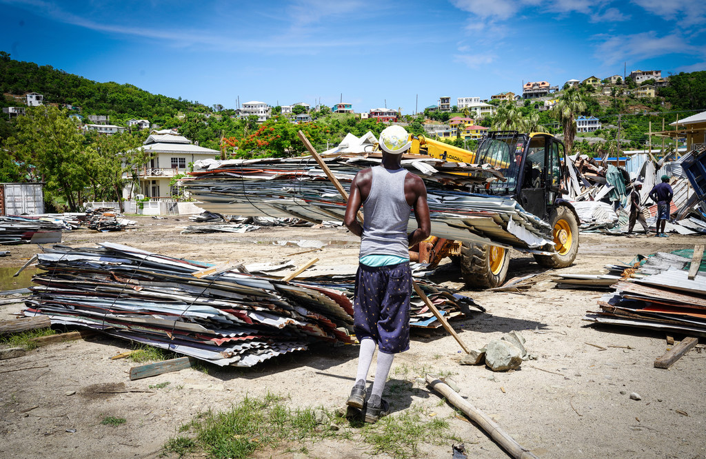 Una excavadora retira los escombros de las casas destruidas en la isla de Unión, tras la devastación causada por el huracán Beryl.