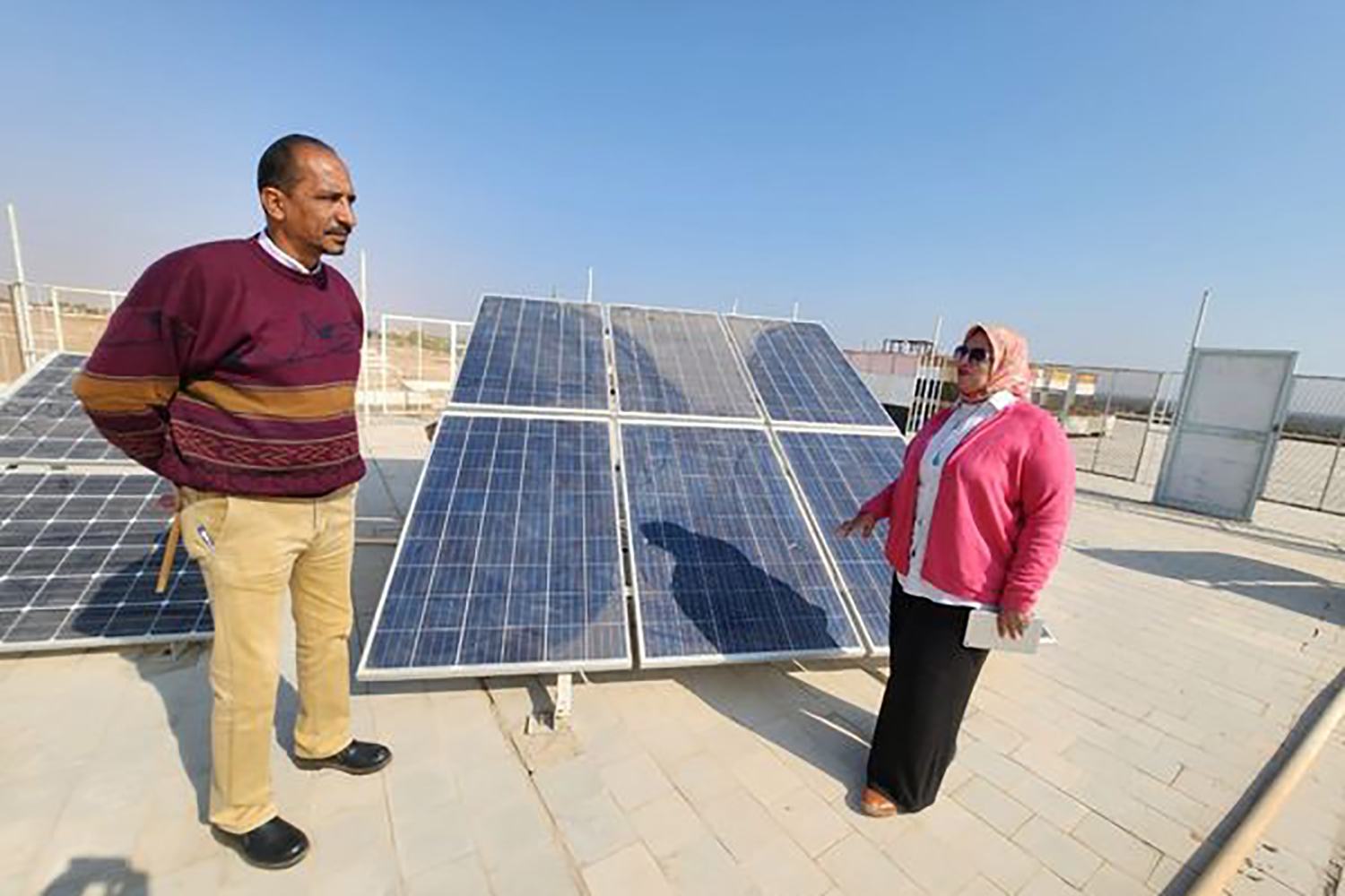معلمان بمدرسة الطاقة الشمسية بموقع المشروع.