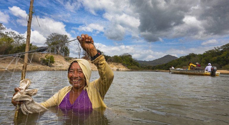 A local woman uses a net to fish in the shallow waters of the Rupununi River in Guyana.