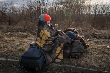 यूक्रेन में जारी संघर्ष से बचने के लिये, एक बच्ची, रोमानिया की सीमा में दाख़िल होते हुए.
