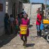 Une femme de Port-au-Prince, en Haïti, transporte de l'eau qu'elle a achetée à un commerçant local.