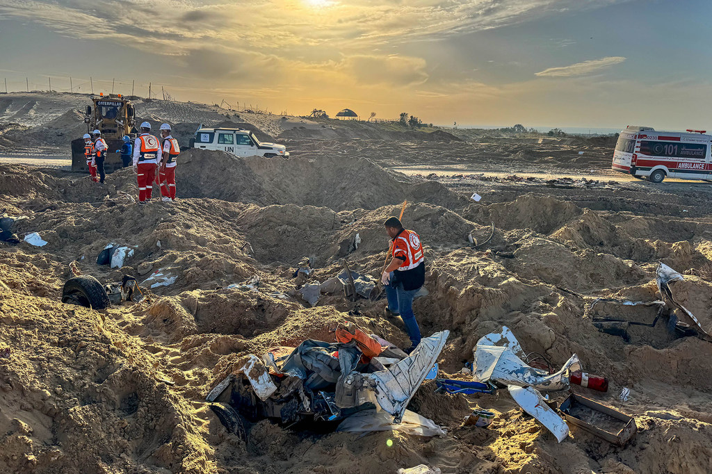 Wafanyakazi wa uokoaji wakitoa kutoa miili ya wafanyakazi wa misaada kutoka kwenye kaburi la pamoja lisilo na kina, akiwemo mfanyakazi wa Umoja wa Mataifa huko Tal Al Sultan.