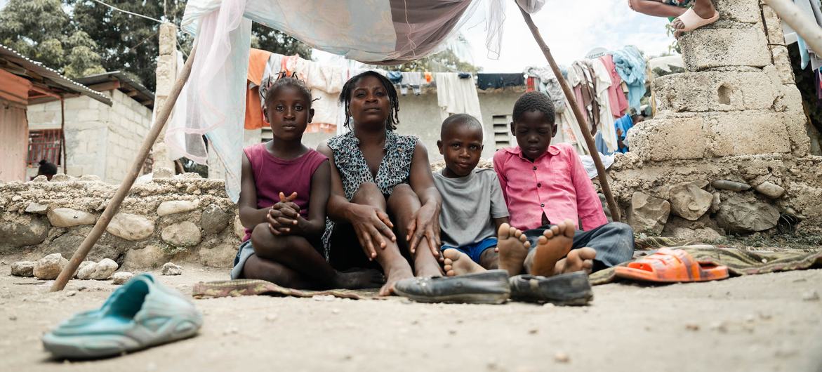 Uma mãe senta-se com seus filhos em um acampamento improvisado em Léogâne, nos arredores da capital haitiana, Porto Príncipe