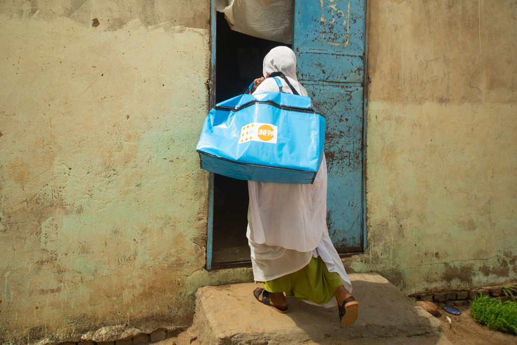 قابلة تزور نساء حوامل في أحد مراكز إيواء النازحين في السودان.