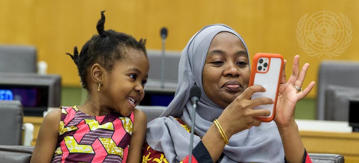 Mwanamke aliyevaa hijab na mtoto mdogo wapiga picha ya selfie katika hafla UMOJA WA MATAIFA kwa ajili ya Siku ya Lugha ya Kiswahili Duniani.