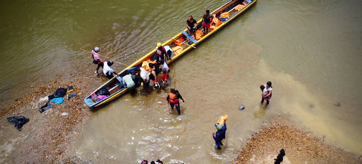 Migrantes desembarcando de una canoa tras cruzar el Darién en Panamá.