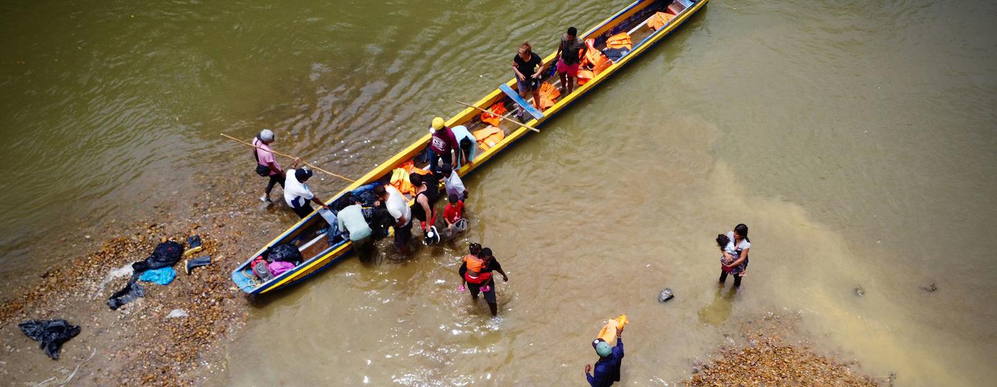 Migrants débarquant d'un canoë après avoir traversé le bouchan du Darién au Panama.
