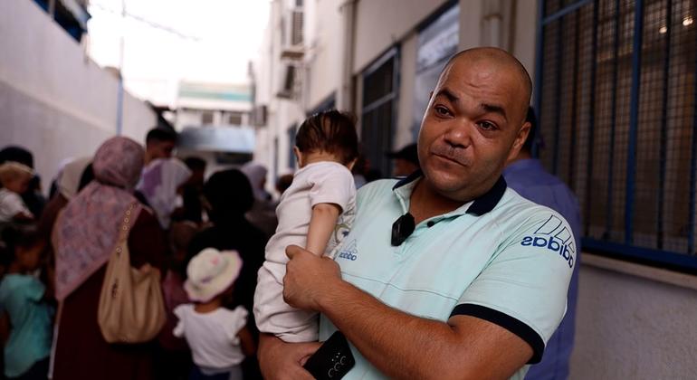 Wael Al-Haj Muhammad chegou a uma clínica da UNRWA no campo de Al-Nuseirat, no centro da Faixa de Gaza, onde seu filho foi vacinado contra a poliomielite.