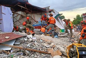 Rescue workers in the Philippines search a building in Bogo City, following the earthquake in Cebu.
