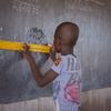 Um aluno usa uma régua no quadro negro em sala de aula, numa escola pública em Kaya, região Centro-Norte, Burkina Faso