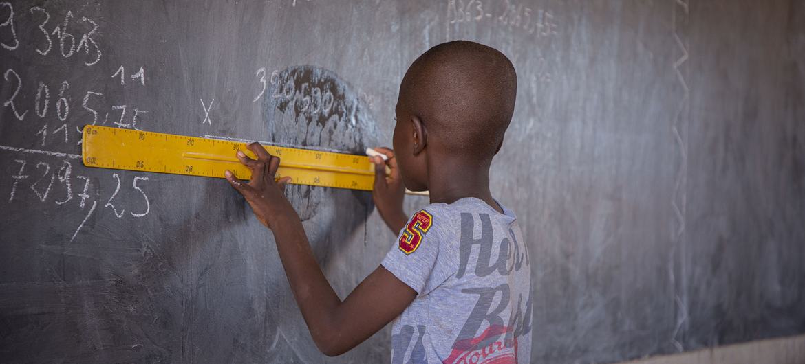 طالب يستخدم مسطرة على السبورة في فصل دراسي بمدرسة عامة في كايا، منطقة الشمال الأوسط، بوركينا فاسو.