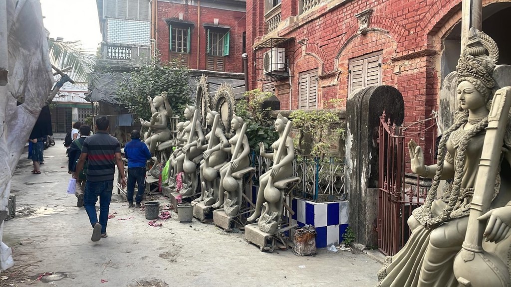 कुमारटोली के कारीगर, दुर्गा पूजा उत्सव के लिए नदी की मिट्टी से देवी की प्रतिमाएँ गढ़ते हैं.