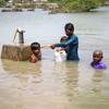 在巴基斯坦信德省，小男孩从被洪水淹没的供水管道取饮用水。