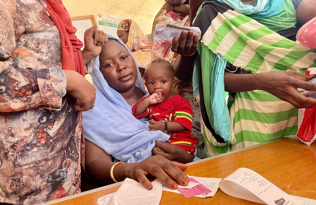 Una mujer recibe dinero como parte de los programas de asistencia humanitaria en Sudán.
