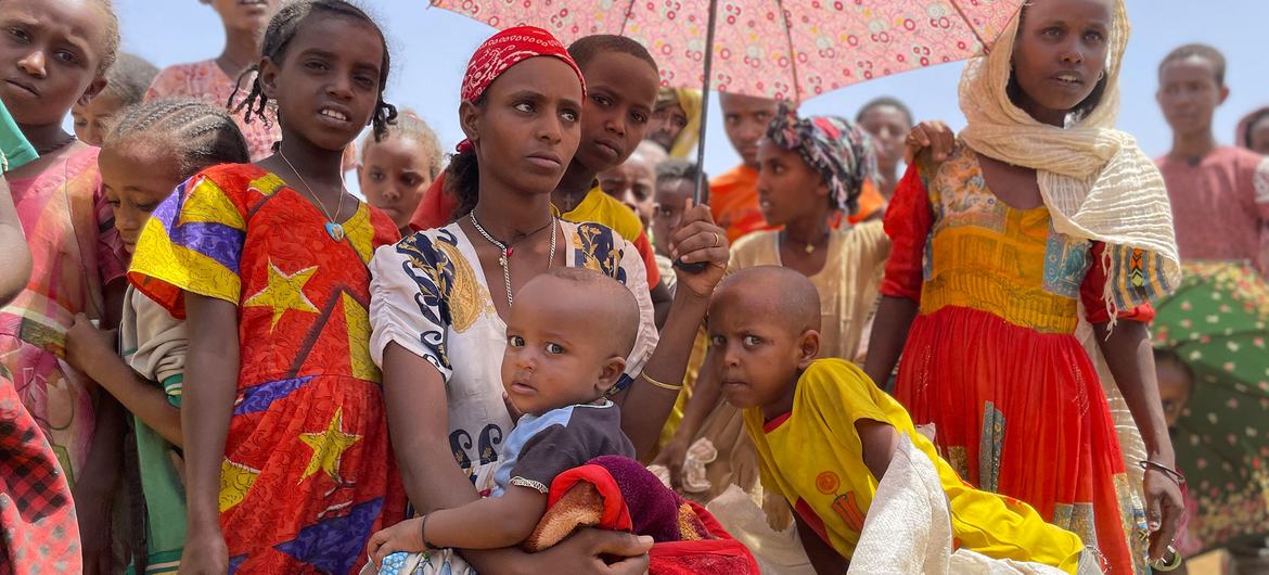 इथियोपिया के टीइग्रे में अदिमेहामेडे में एक भोजन वितरण स्थल पर महिलाएं और बच्चे प्रतीक्षा करते हुए.
