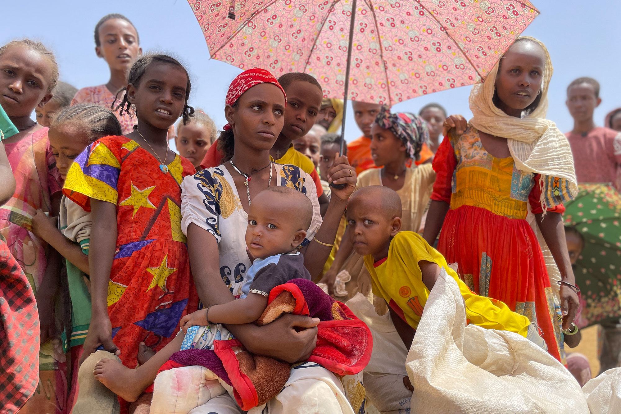 在埃塞俄比亚提格雷地区的阿迪梅哈梅迪，妇女和儿童在食物分发点等待。