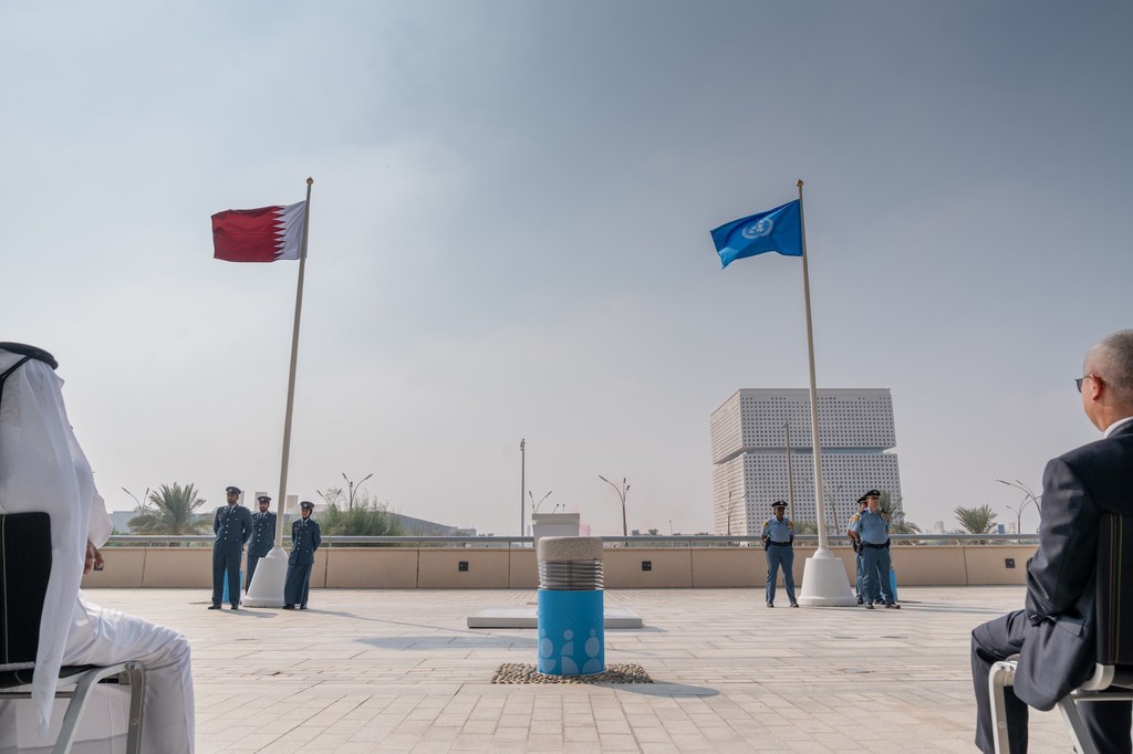 Les drapeaux des Nations Unies et de l'État du Qatar flottent au Centre national des congrès du Qatar, lieu du deuxième Sommet mondial pour le développement social.