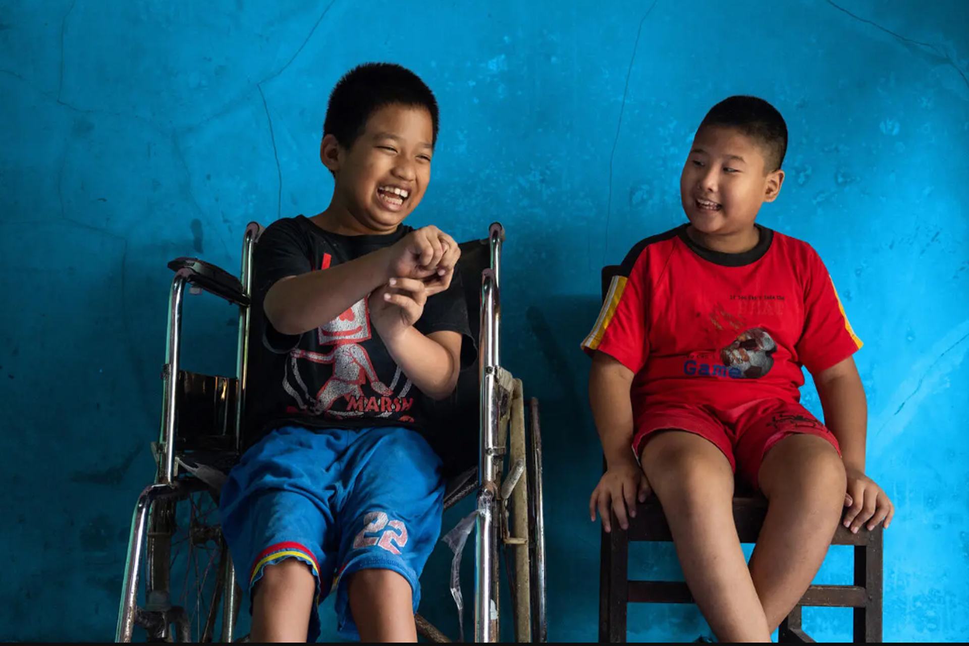 سيفول (على اليسار)، 12 عاما، يعاني من إعاقة جسدية،  وهو يجلس بجوار أفضل صديق له كيفن سابوترا (على اليمين)، 9 أعوام، الذي يعاني من إعاقة بصرية، في منزل سيفول في بانيوماس، وسط جاوا، إندونيسيا.