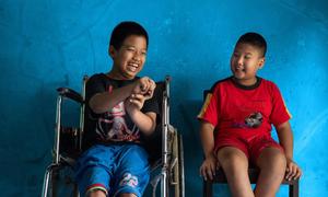 Un niño de 12 años con discapacidad física se sienta junto a su mejor amigo, un niño de 9 años con discapacidad visual, en Java Central, Indonesia.