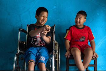 Un niño de 12 años con discapacidad física se sienta junto a su mejor amigo, un niño de 9 años con discapacidad visual, en Java Central, Indonesia.