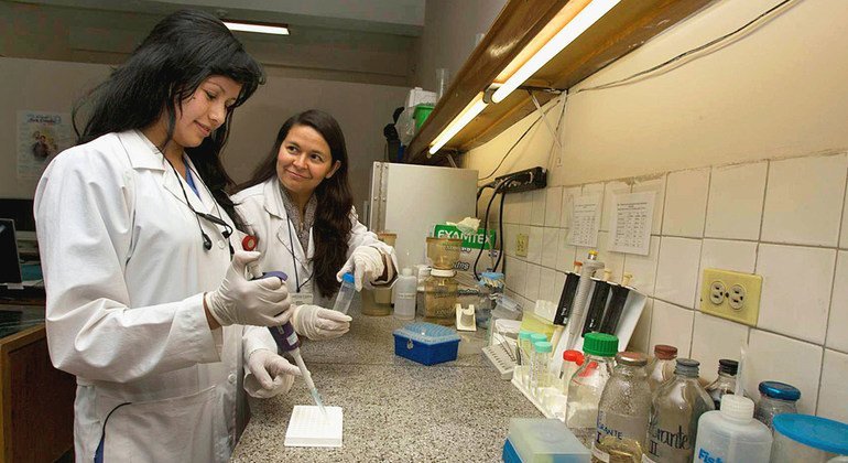 Um assistente de pesquisa (à esquerda) recebe treinamento de um biólogo no Instituto Nacional de Câncer da Colômbia