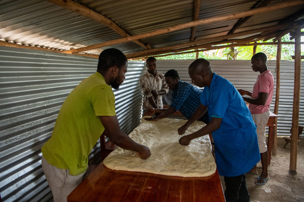 Cadet Kavugwa Shebulike (à droite) prépare la pâte avec ses employés et stagiaires dans sa boulangerie du camp de réfugiés de Nyankanda.