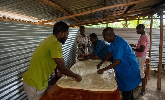 Cavalry cadet Kavugwa Shebulike (right) prepares dough with staff and practitioners at his bakery in Nyankanda refugee camp.
