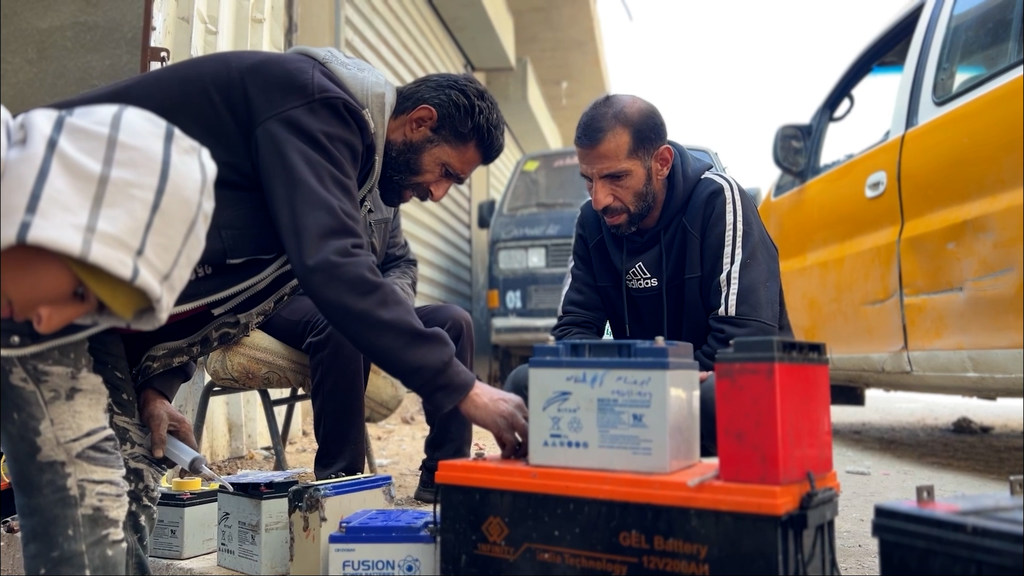 Alaa Abu Sitta y otros técnicos reparan baterías para sistemas de energía alternativa destinados a paliar la escasez de electricidad en Gaza.