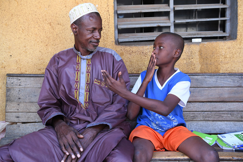 Mvulana ambaye ana ugumu wa kusikia anamfundisha baba yake lugha ya ishara huko Bouaké, Côte d'Ivoire.