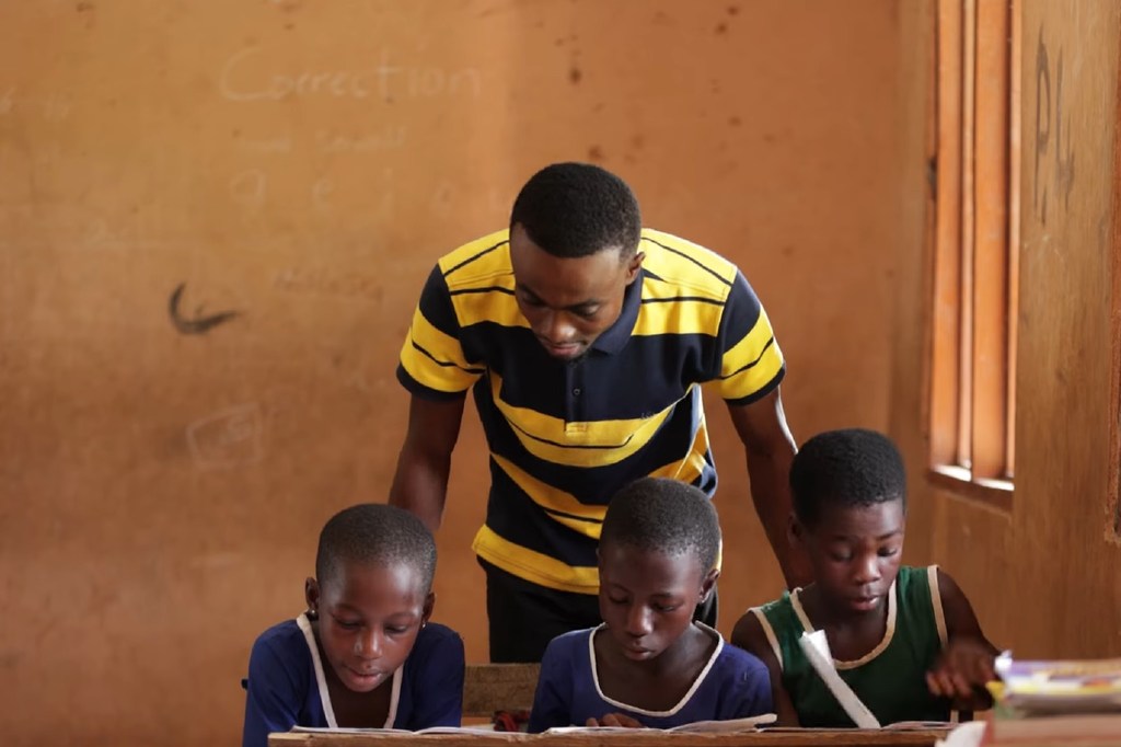 在加纳的一所学校，老师正在帮助孩子学习阅读。