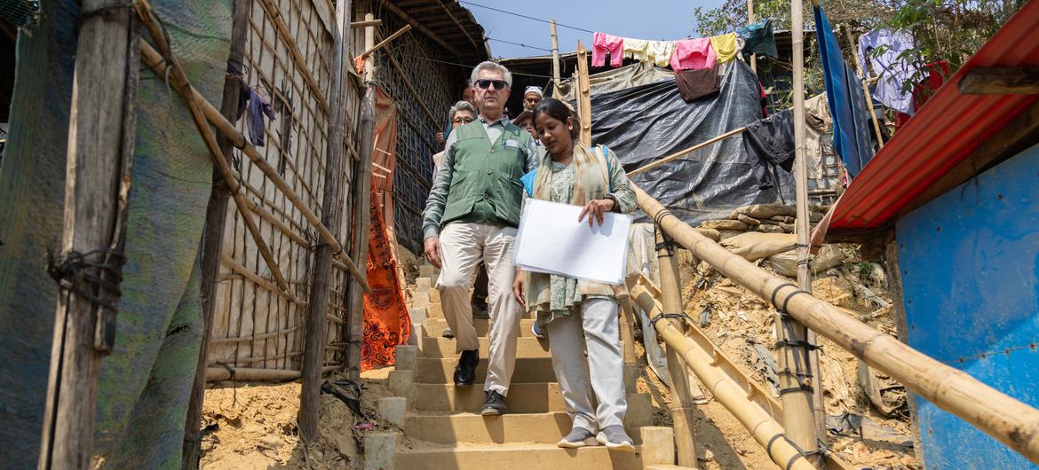 UNHCR ہائی کمشنر فلیپو گرانڈی ایک مقامی خاتون کے ہمراہ بنگلہ دیش کے کاکس بازار میں روہنگیا پناہ گزین کیمپ میں سیڑھیوں کے ایک سیٹ سے نیچے چل رہے ہیں۔